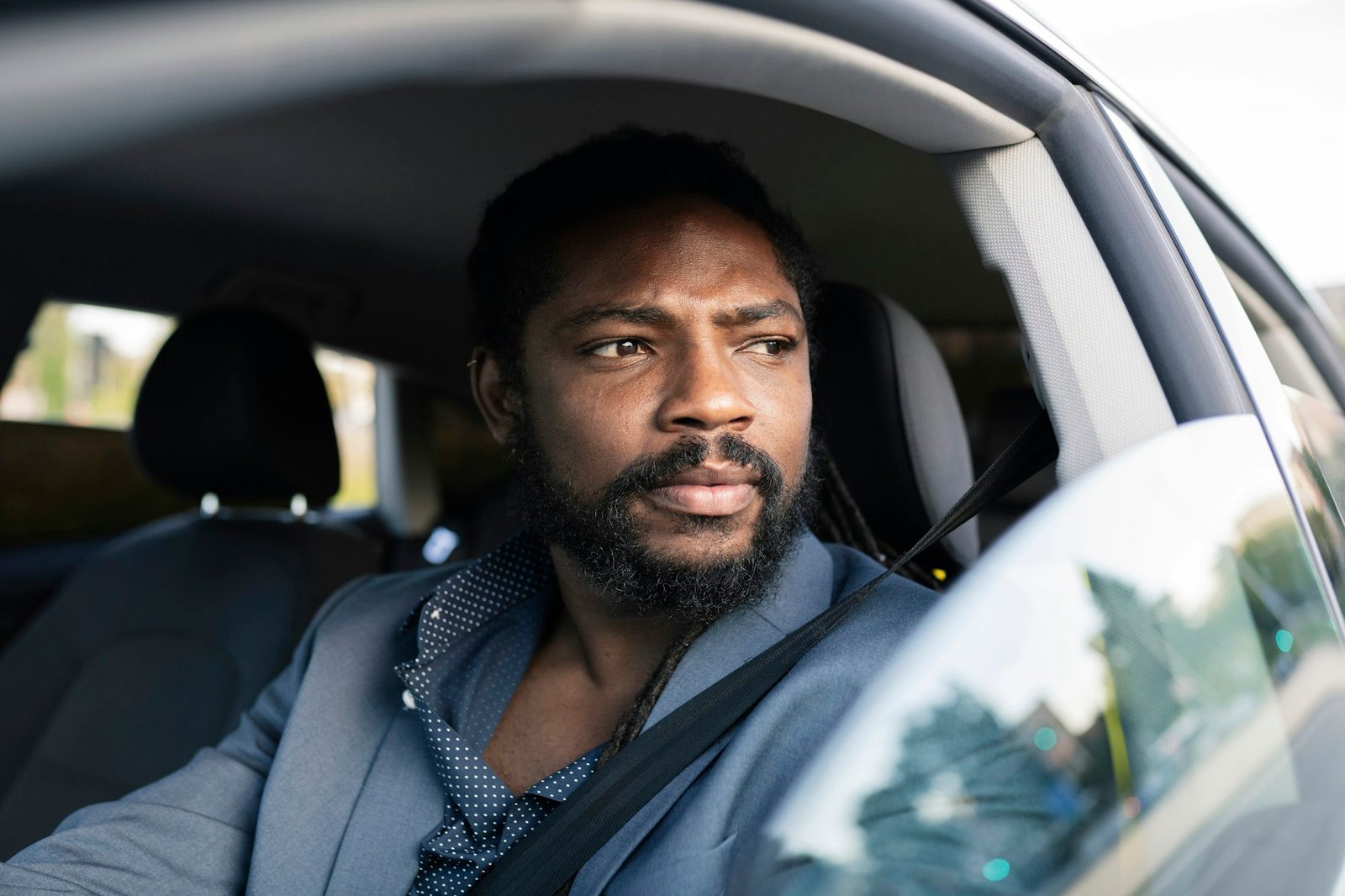 handsome afro american business man driving a car